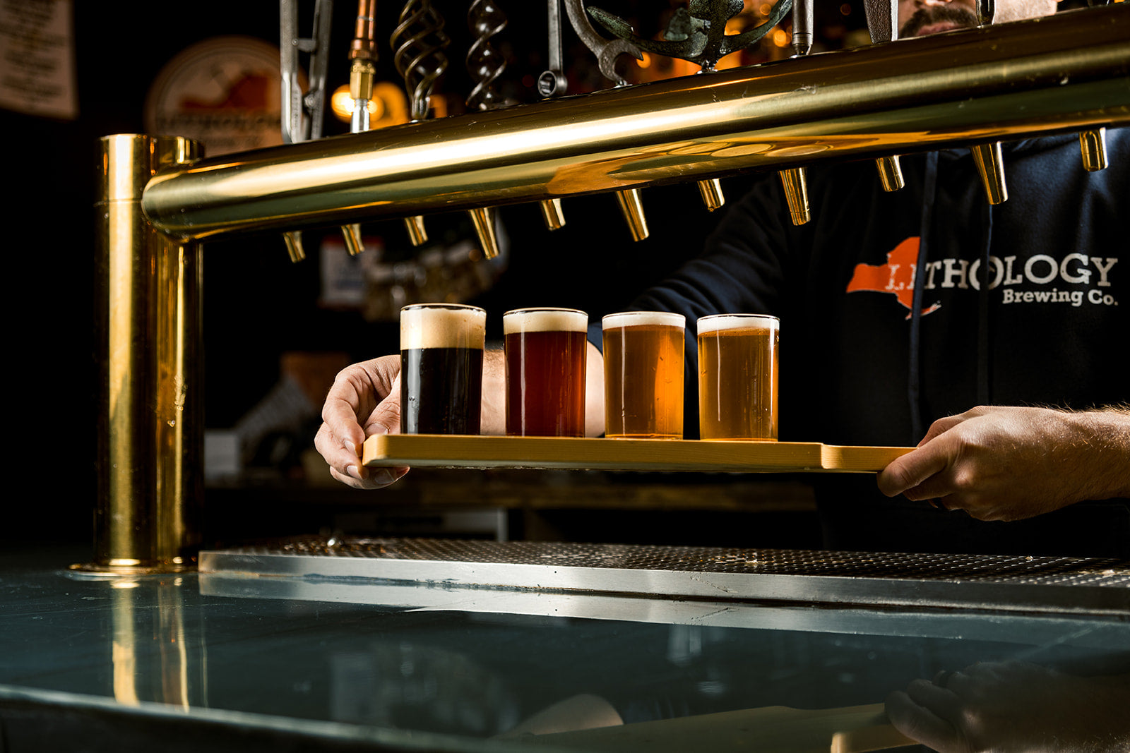 4  5oz tastings of beer from dark, amber, golden and light on a wooden board 